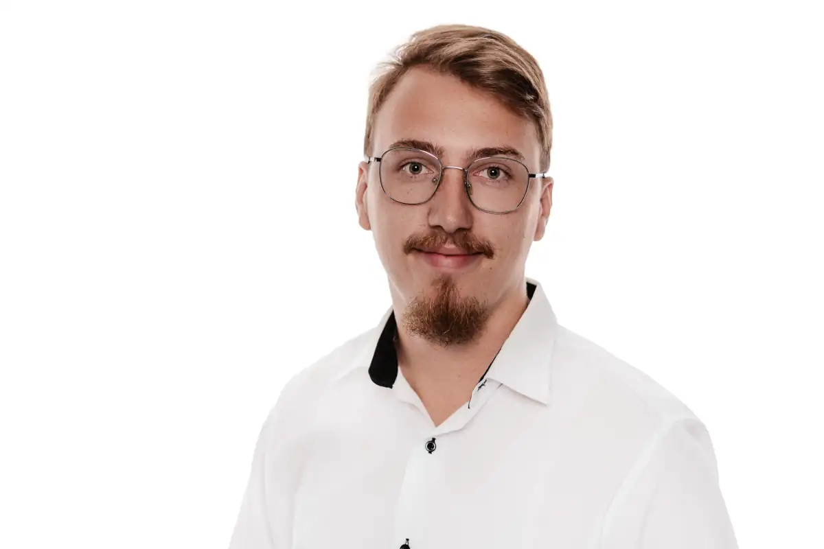 Professionelles Porträt eines jungen Mannes mit Brille und modischem Hemd Dominic Scott