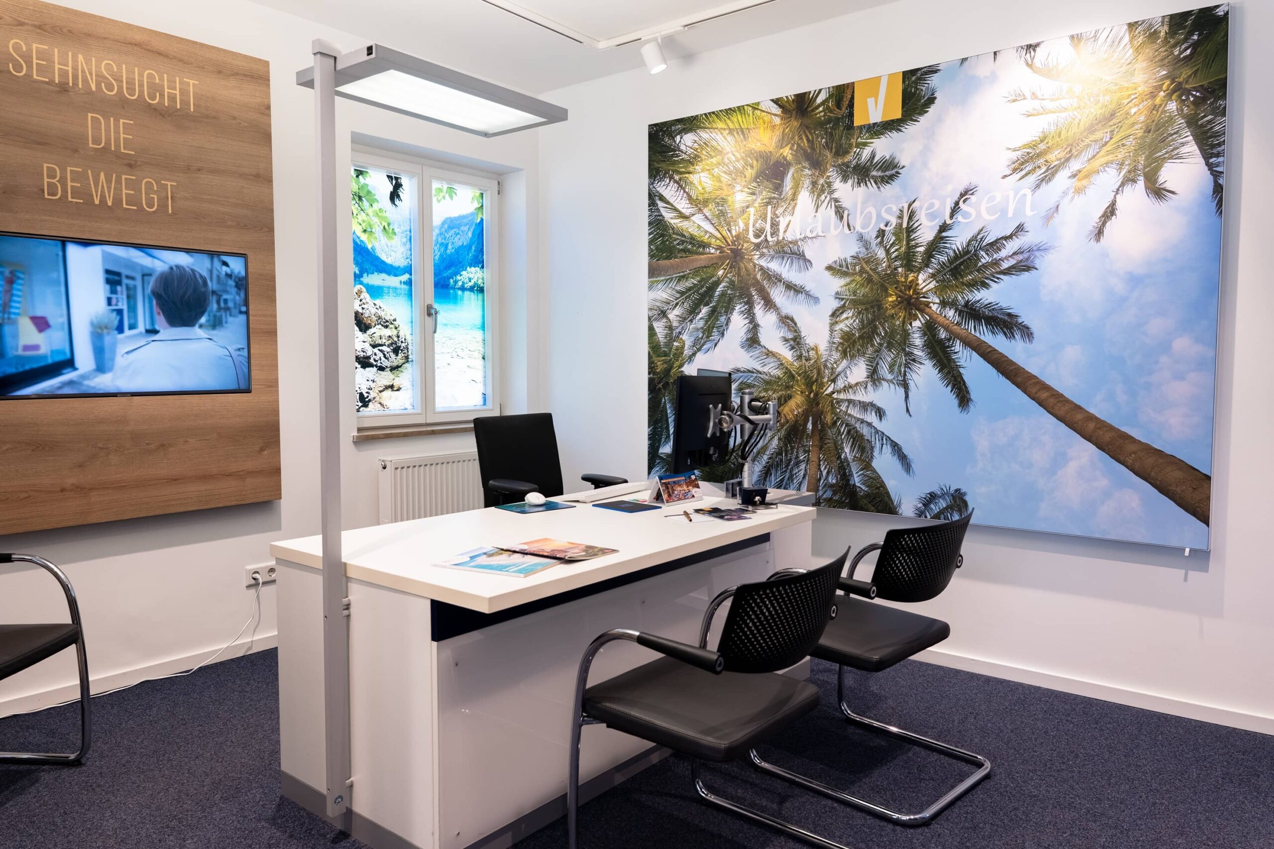 Urlaubsberatung in modernem Ambiente mit inspirierenden Bildern an der Wand Blick auf einen modernen Beratungsraum mit Urlaubsbildern und einem Schreibtisch, ideal für Reiseplanung und Tourismus.